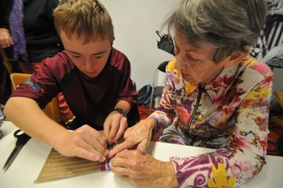 Young artist Mathew Deane weaving a bag with his grandma Florence